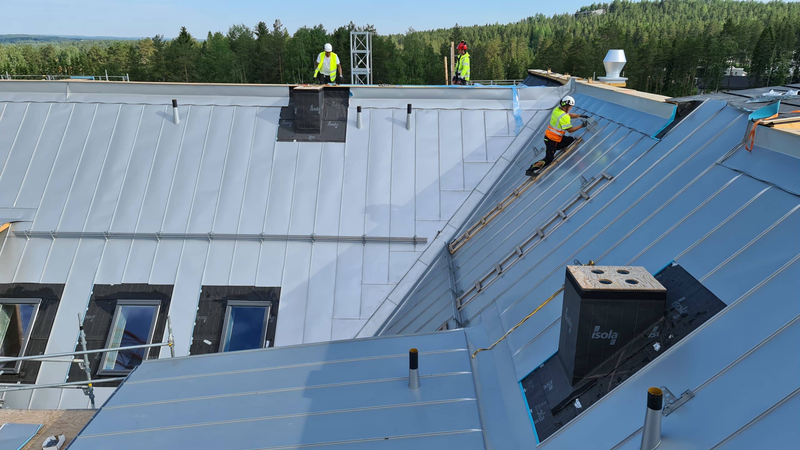 Plåtslagare i arbete på ett villatak